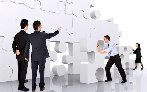 business teamwork – business men making a puzzle